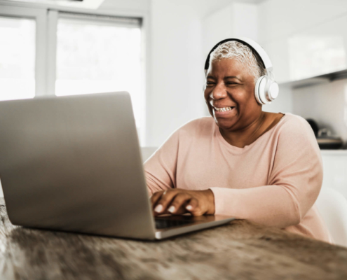 Older woman smiling at laptop computer